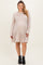 woman wearing a beige ribbed long sleeve maternity dress with a flared hemline and visible baby bump