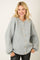 woman wearing a light grey oversized button-up sweater with ribbed texture and puffy sleeves