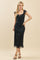 woman wearing a black midi dress with floral print and a lace-up neckline, standing in a relaxed pose