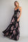 woman wearing a black floral maxi dress with a deep v-neck and adjustable straps