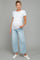 woman wearing a white short sleeve maternity top and light blue wide-leg jeans, showing her baby bump