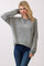 woman wearing a gray and white striped long sleeve sweatshirt with a relaxed fit and a v-neckline, paired with blue jeans