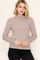 woman wearing a striped taupe long sleeve turtleneck top with a fitted style