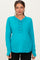 woman wearing a teal long sleeve maternity top with button details and a visible baby bump