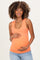 woman wearing an orange maternity tank top and holding her baby bump
