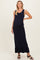 woman wearing a navy blue ribbed maternity maxi dress with a ruffled hem and a visible baby bump