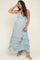 woman wearing a light blue maternity maxi dress with ruffled tiers and spaghetti straps, showing her baby bump