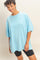 woman wearing a light blue oversized t-shirt paired with black bike shorts