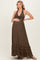 woman wearing a brown halter maternity maxi dress with tiered ruffle details and holding her baby bump