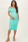 woman wearing a mint green off-shoulder maternity dress with ruching, holding her baby bump