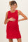woman wearing a red crochet maternity dress and gently holding her baby bump