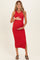 woman wearing a red ribbed maternity dress and showing her baby bump