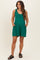 woman wearing a green maternity romper with tie shoulder details and side pockets, showcasing her baby bump