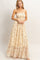 woman wearing a yellow floral maxi dress with a smocked bodice and ruffled hem