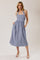 woman wearing a blue and white gingham halter neck midi dress with pockets