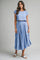 woman wearing a light blue cropped top and matching flowing midi skirt with sandals