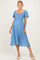 woman wearing a light blue maternity dress with short flutter sleeves and a square neckline, featuring polka dot details and a baby bump