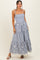 woman wearing a blue and white striped maxi dress with embroidered flowers and a tiered skirt
