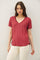 woman wearing a burgundy v-neck t-shirt with short sleeves and a relaxed fit