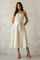 woman wearing a cream-colored midi dress with adjustable spaghetti straps and a waist tie detail