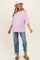 woman wearing a light pink oversized maternity top and blue rolled-up jeans, with a white bucket hat