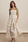 woman wearing a floral maxi dress with smocked bodice, ruffled tiers, and green bow straps