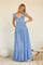 woman wearing a light blue maxi dress with ruffled sleeves and button details, standing gracefully against a neutral backdrop