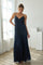 woman wearing a navy blue maxi dress with white polka dots and a fitted bodice, standing indoors in natural light