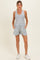 woman wearing a gray maternity tank top and light blue maternity shorts with pockets
