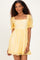 woman wearing a yellow short puff sleeve dress with a square neckline and floral embroidery