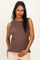 woman wearing a brown sleeveless maternity top and holding her baby bump