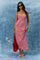 woman wearing a red and white striped maxi dress with thin straps, holding a red tote bag and wearing sunglasses