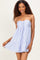 woman wearing a lavender strapless mini dress with a tie detail and ruffle hem