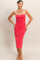 woman wearing a fitted red midi dress with white straps and a simple silhouette, standing barefoot on a neutral background