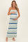 woman wearing a striped maternity maxi dress in green and blue, holding her baby bump