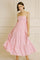 woman wearing a pink tiered maxi dress with spaghetti straps and a smocked bodice