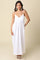 woman wearing a white maxi dress with adjustable spaghetti straps and a flowy silhouette