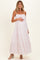 woman wearing a light pink striped maternity maxi dress and holding her baby bump