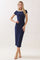 woman wearing a navy blue midi dress with short sleeves and white trim, standing in a neutral background