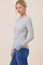 woman wearing a striped long sleeve top in light blue and white paired with high-waisted jeans