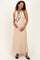 woman wearing a beige ribbed maternity maxi dress with a black tie detail and holding her baby bump