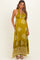 woman wearing a green patterned maternity maxi dress with a halter neckline and pockets, showing her baby bump