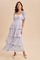 woman wearing a light blue floral tiered maxi dress with short sleeves and a scoop neckline