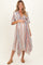 woman wearing a striped maternity maxi dress with a deep v-neck and holding her baby bump