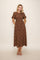 woman wearing a brown floral midi dress with puff sleeves and pockets