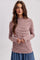 woman wearing a pink and white striped long sleeve top with a high neckline and relaxed fit