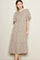 woman wearing a beige floral midi dress with puff sleeves and a tiered skirt