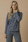 woman wearing a navy blue and white striped long sleeve top with matching pants, styled casually with a necklace