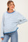 woman wearing a striped blue and white oversized maternity sweater with a relaxed fit and round neckline