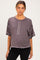 woman wearing a gray maternity wear short sleeve henley top with button details and contrasting stitching